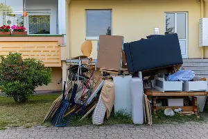 A junk pile in the front of a Portland home. Call or contact Mike & Dad's Hauling if you have unwanted junk removal needs.
